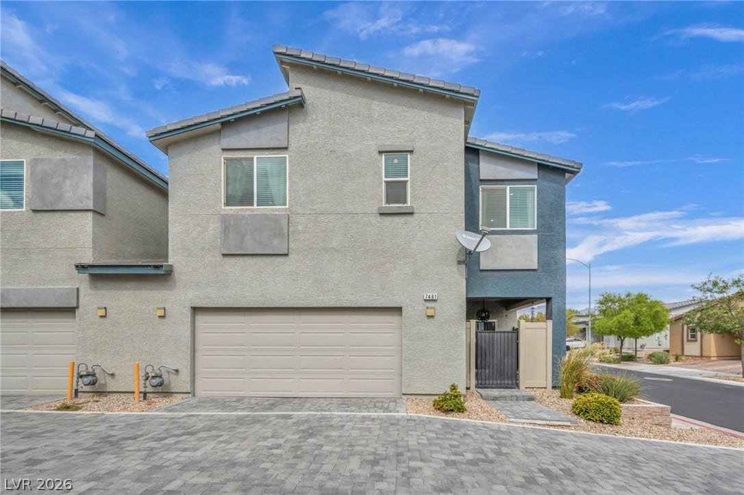 7481 Garnet Moon Street, North Las Vegas, NV 89084 Modern multi-level exterior architecture features clean stucco finishes and a paved driveway leading to the garage.