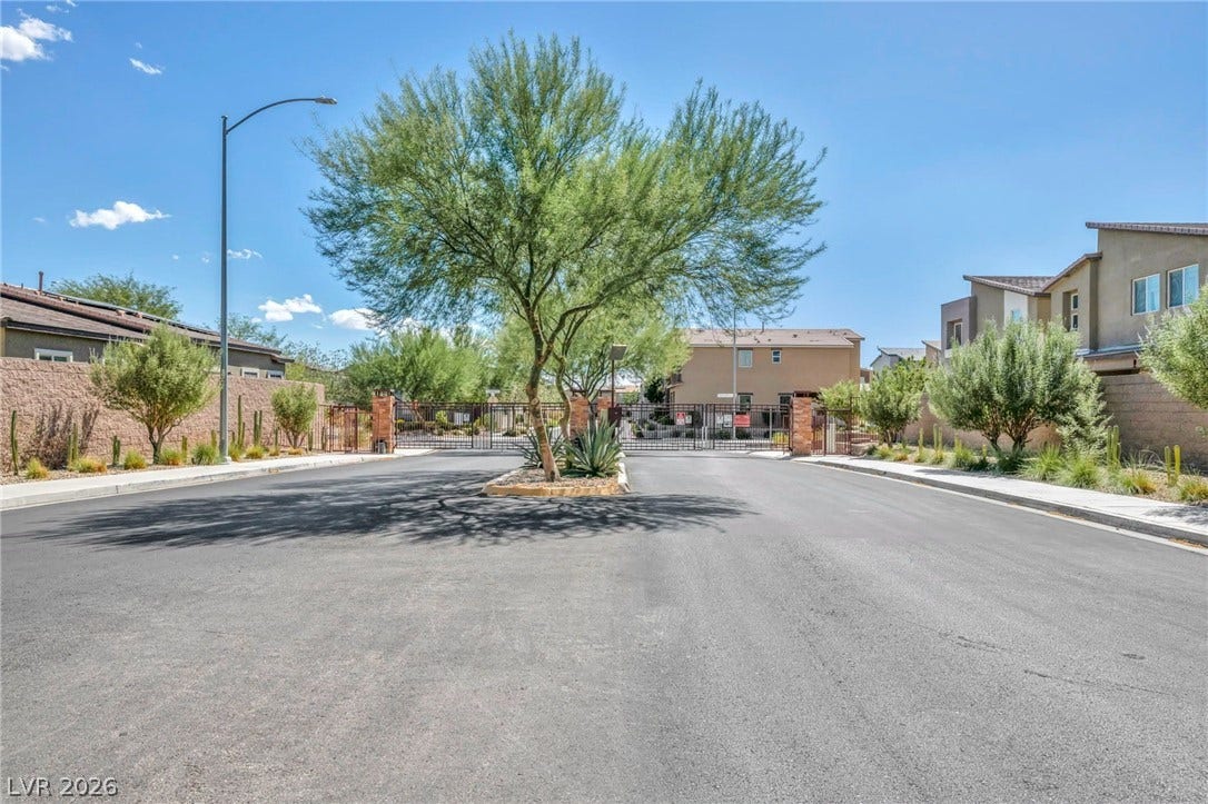 7481 Garnet Moon Street, North Las Vegas, NV 89084 Secure gated access entry welcomes residents home along a neatly paved street.