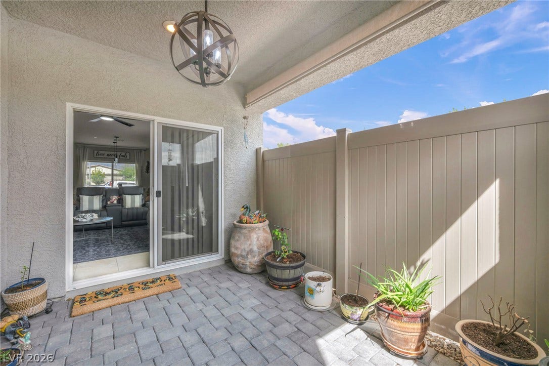 7481 Garnet Moon Street, North Las Vegas, NV 89084 An inviting covered patio features stone-style pavers and a secure vinyl privacy fence.