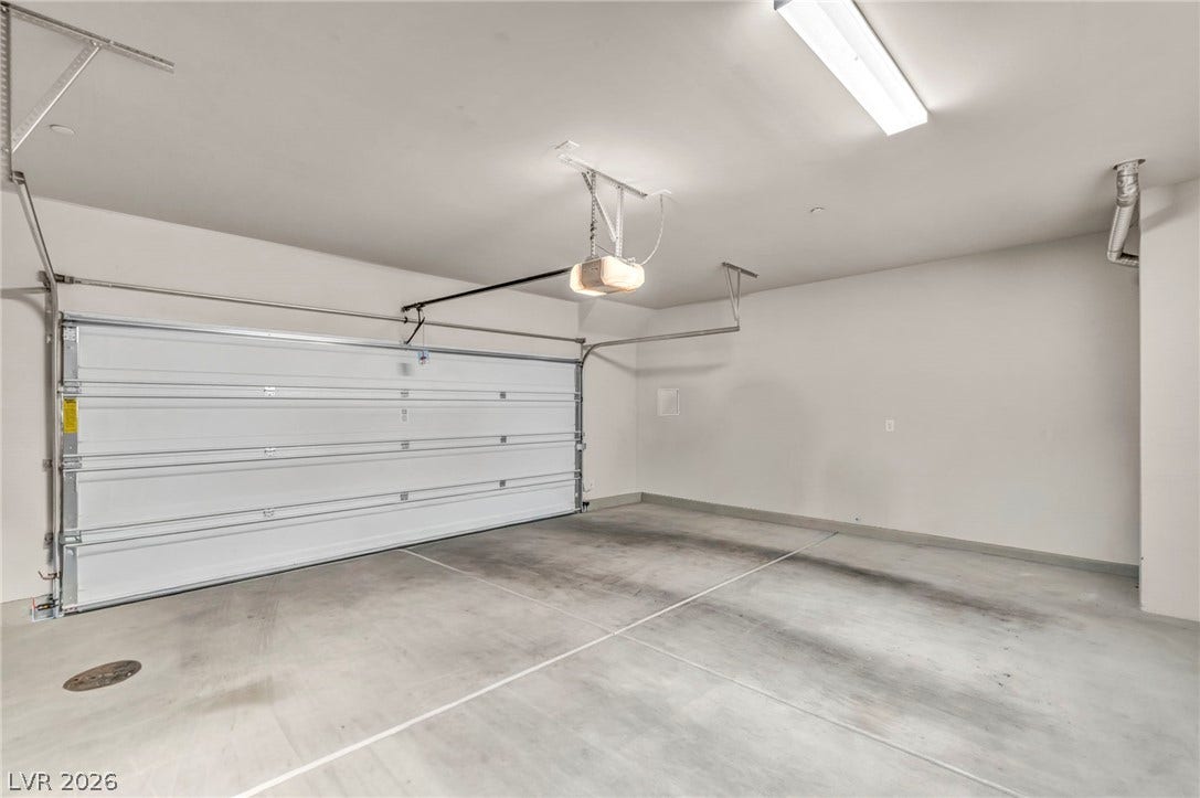 7481 Garnet Moon Street, North Las Vegas, NV 89084 An automatic overhead door secures this spacious garage featuring clean concrete flooring.