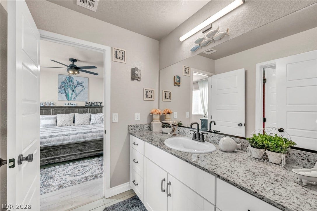 7481 Garnet Moon Street, North Las Vegas, NV 89084 Polished granite countertops complement the clean white cabinetry in this well-appointed bathroom.