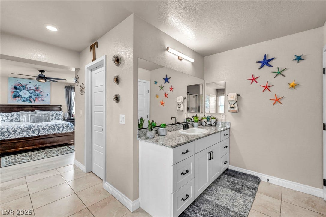 7481 Garnet Moon Street, North Las Vegas, NV 89084 Tiled floors and granite countertops define this modern vanity area adjacent to the main bedroom.