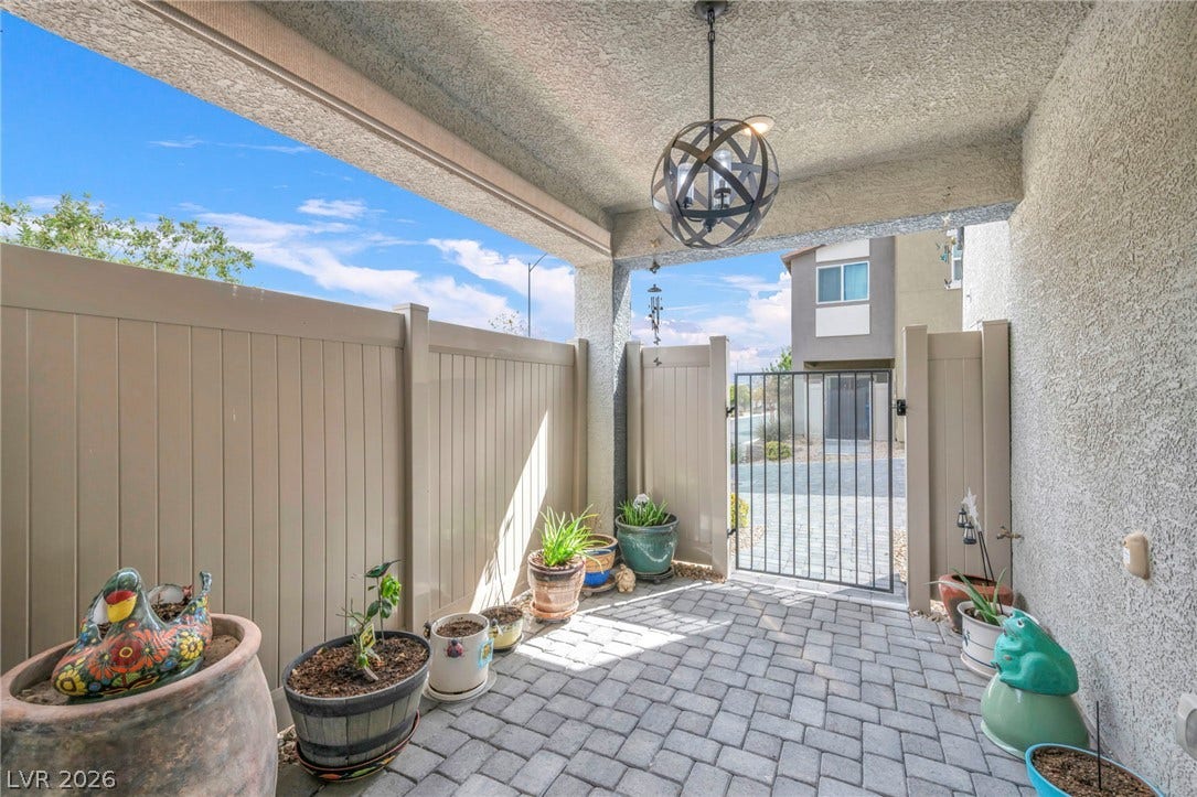 7481 Garnet Moon Street, North Las Vegas, NV 89084 An inviting gated courtyard patio features elegant stone pavers under a protective covered ceiling.
