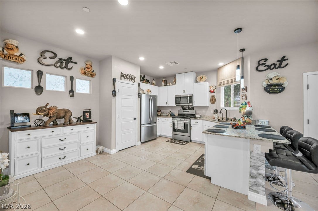 7481 Garnet Moon Street, North Las Vegas, NV 89084 An open kitchen highlights durable tile flooring, stone counters, and a central preparation island.