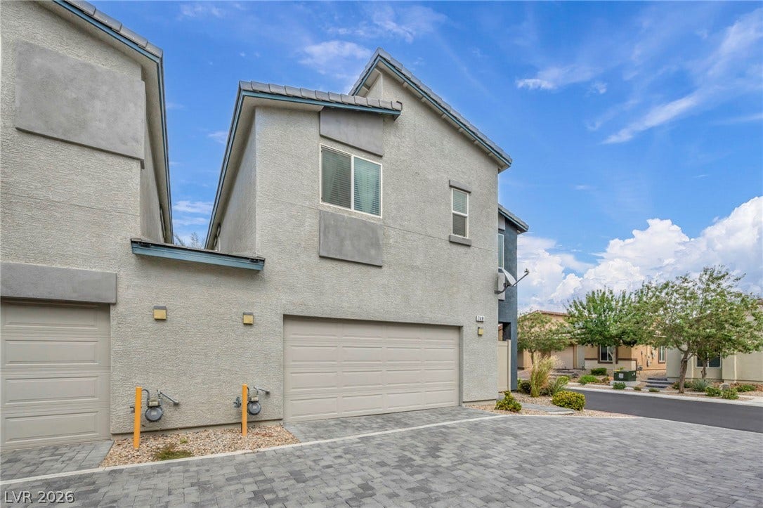 7481 Garnet Moon Street, North Las Vegas, NV 89084 Multi-level modern construction features integrated garage parking and durable tile roofing beneath blue skies.