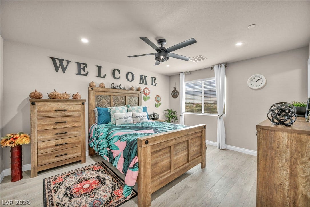 7481 Garnet Moon Street, North Las Vegas, NV 89084 Recessed lighting and wide-plank flooring elevate this airy bedroom featuring a large window.