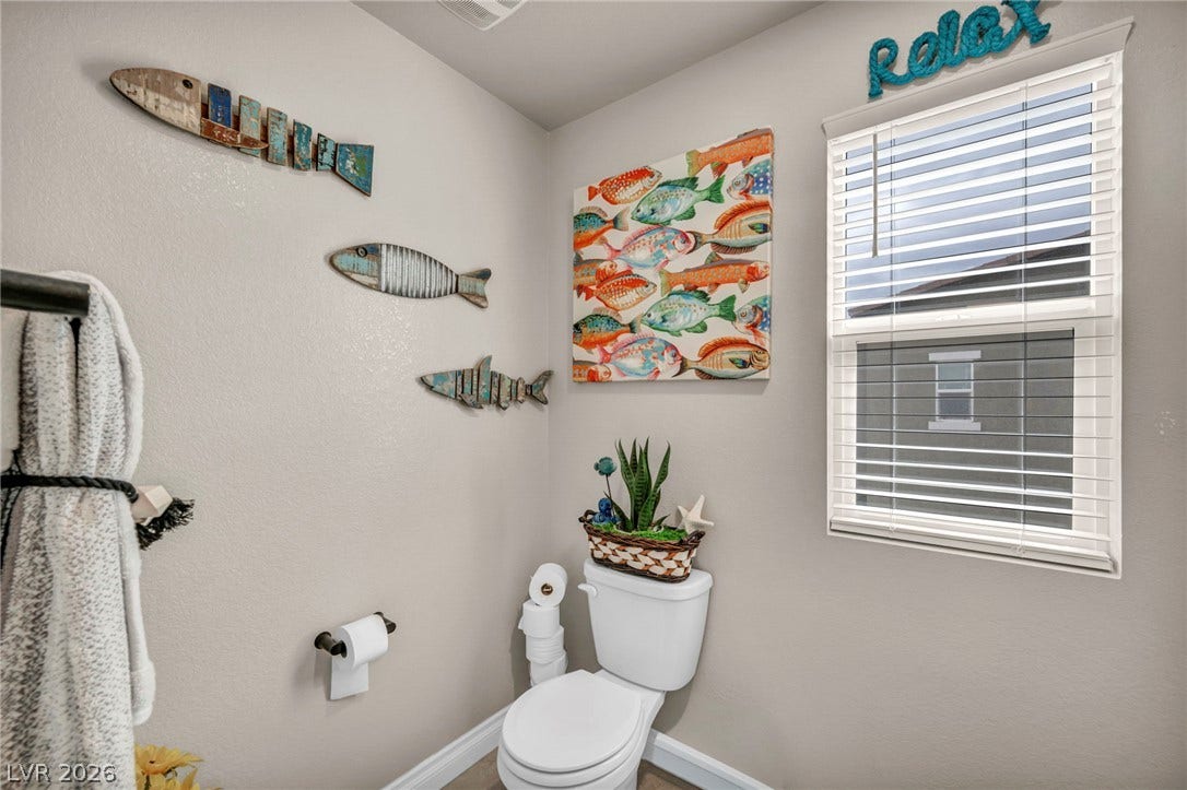 7481 Garnet Moon Street, North Las Vegas, NV 89084 Natural light pours through a wide window, illuminating this clean and simple bathroom space.