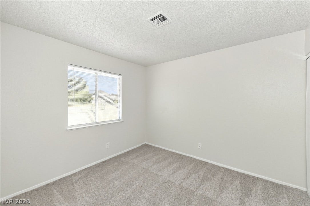 378 Tierra Street, Henderson, NV 89014 A window brings natural light into this bedroom featuring soft wall-to-wall carpeting.