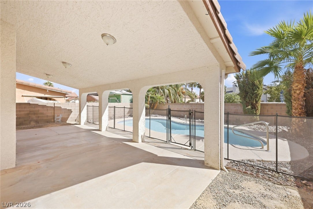 378 Tierra Street, Henderson, NV 89014 An arched covered patio overlooks a fenced backyard swimming pool under sunny desert skies.
