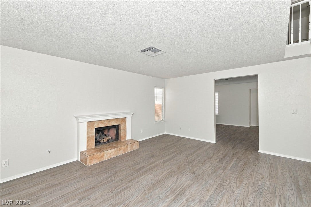 378 Tierra Street, Henderson, NV 89014 A classic fireplace with tile trim anchors this open living space featuring wood-look flooring.
