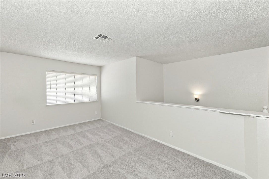378 Tierra Street, Henderson, NV 89014 Plush carpeting and a half-wall partition define this versatile upper-level bonus area.