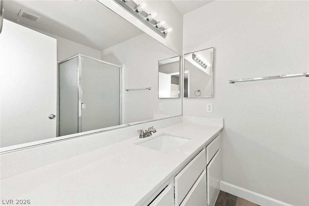 378 Tierra Street, Henderson, NV 89014 A spacious vanity countertop sits beneath an expansive mirror in this updated bathroom.