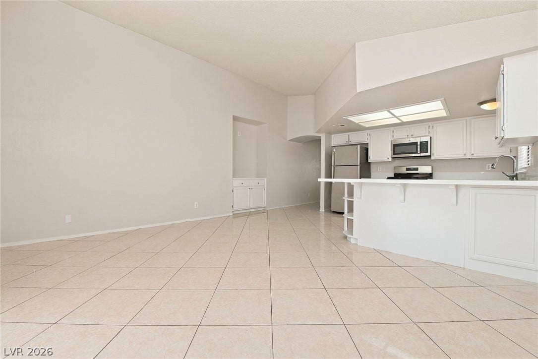 4448 Ryder Lane, North Las Vegas, NV 89031 Gleaming tile floors stretch across a light-filled kitchen and dining area under high vaulted ceilings.