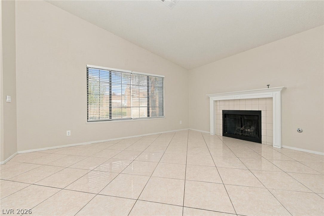 4448 Ryder Lane, North Las Vegas, NV 89031 Polished tile flooring and a classic fireplace define this airy living space.