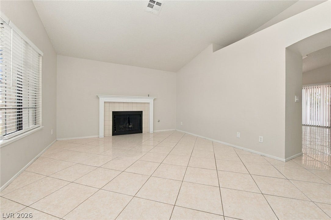 4448 Ryder Lane, North Las Vegas, NV 89031 Tiled flooring and a classic fireplace anchor this open living space under vaulted ceilings.