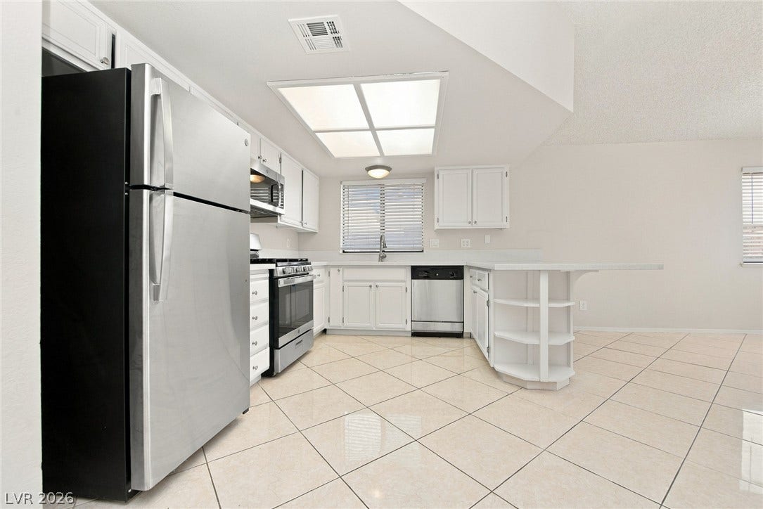 4448 Ryder Lane, North Las Vegas, NV 89031 Polished tile flooring and classic white cabinetry define this bright, open kitchen space.