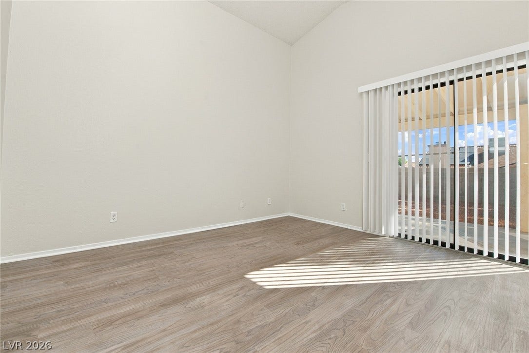 4448 Ryder Lane, North Las Vegas, NV 89031 Sliding glass doors open to the outdoors, highlighting the wood-look flooring and high ceilings.