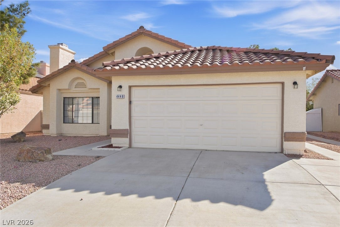 4448 Ryder Lane, North Las Vegas, NV 89031 An inviting exterior features a tiled roof and a spacious concrete driveway leading to the garage.