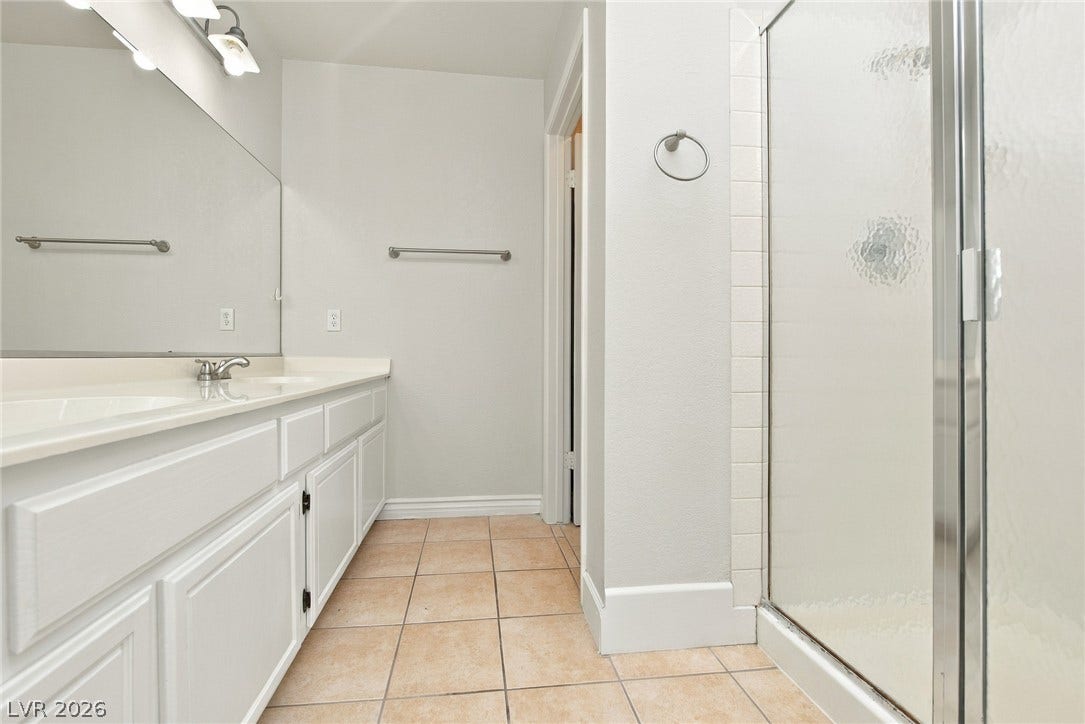 4448 Ryder Lane, North Las Vegas, NV 89031 Tiled flooring runs throughout this well-appointed bathroom featuring a glass-enclosed shower.