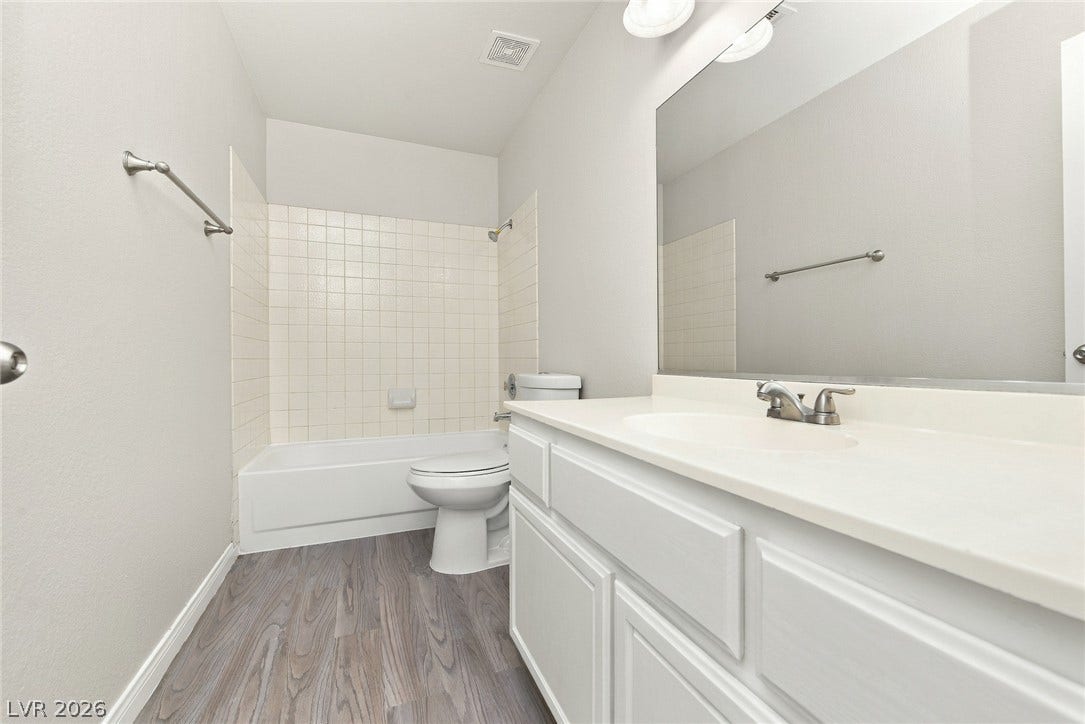 4448 Ryder Lane, North Las Vegas, NV 89031 A clean vanity and a tiled tub shower combination define this functional space.