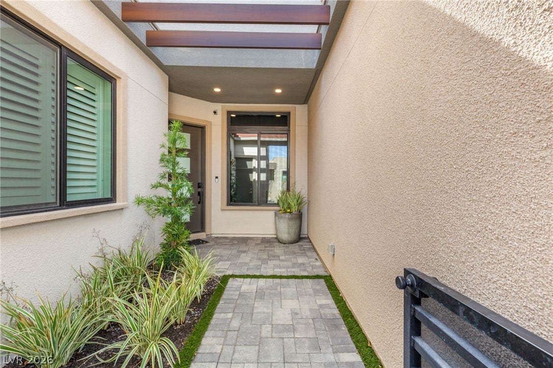 11041 Concord Valley Drive, Las Vegas, NV 89135 Welcoming stone paver pathway leads directly to a private stucco entryway featuring overhead architectural beams.