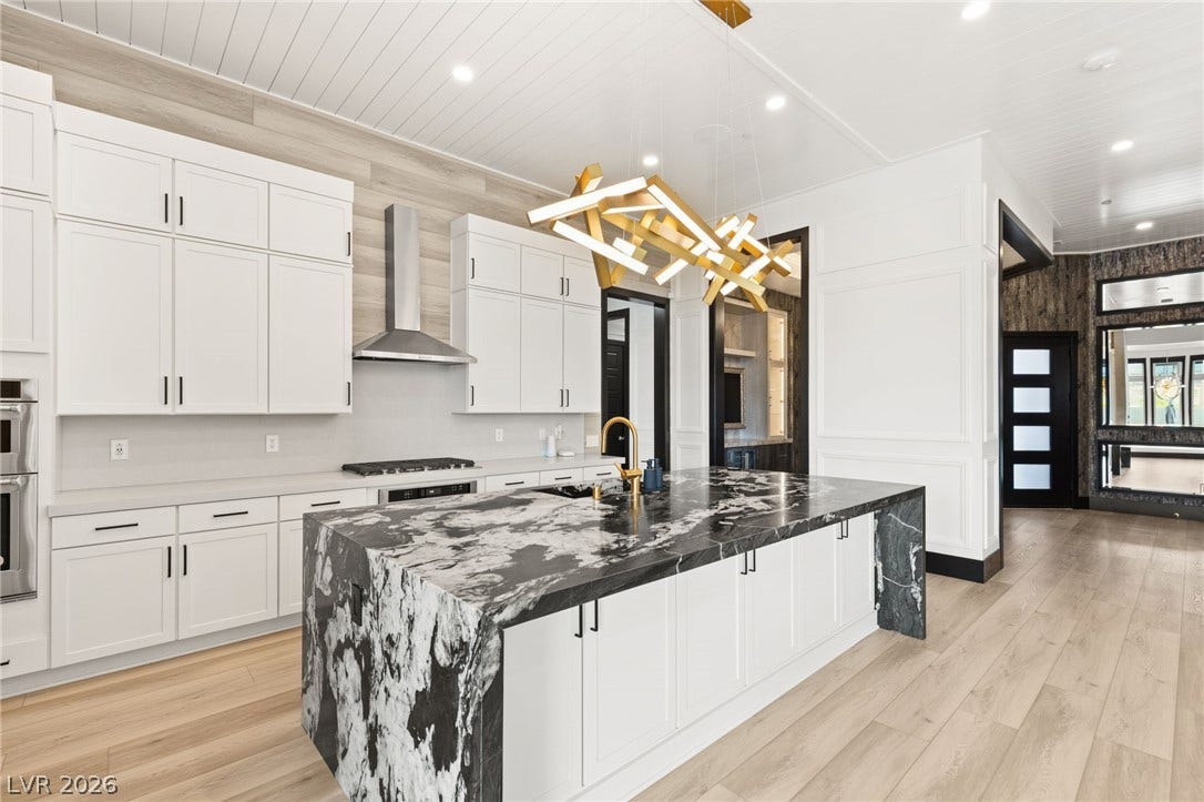 11041 Concord Valley Drive, Las Vegas, NV 89135 Dramatic stone counters anchor an open culinary space lined with elegant hardwood flooring.