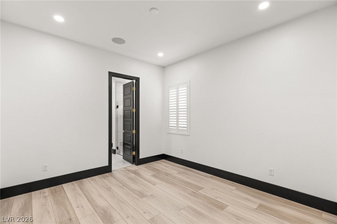 11041 Concord Valley Drive, Las Vegas, NV 89135 Crisp white walls contrast with dark trim and wood-plank flooring in this versatile space.
