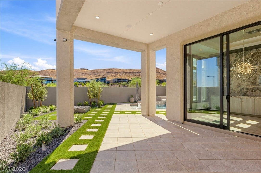 11041 Concord Valley Drive, Las Vegas, NV 89135 Sliding glass doors open to a covered patio overlooking manicured turf and mountain views.