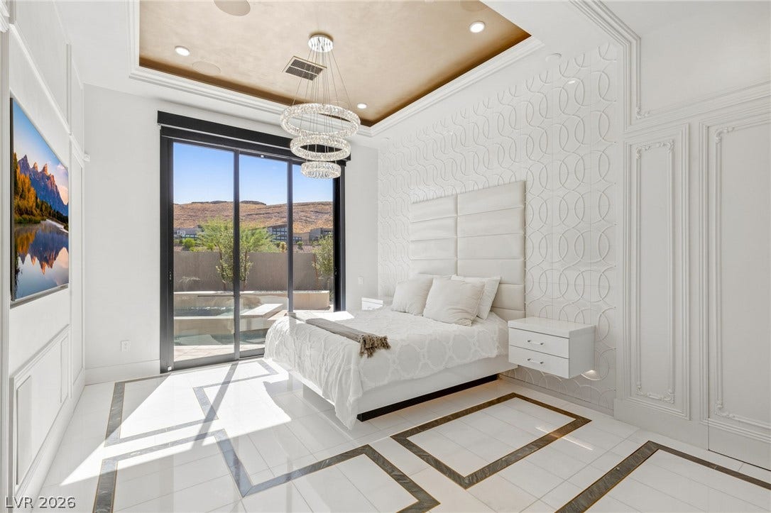 11041 Concord Valley Drive, Las Vegas, NV 89135 Elegant crown molding and geometric floor inlays frame a bedroom with sliding glass doors.