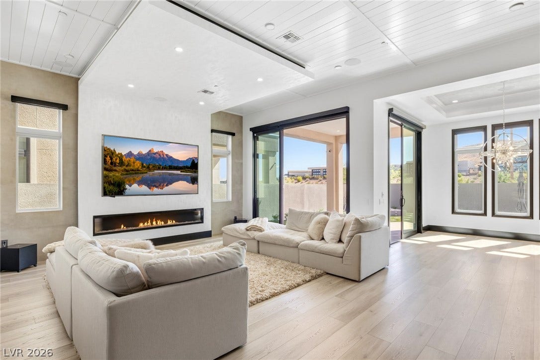 11041 Concord Valley Drive, Las Vegas, NV 89135 Recessed lighting, wood floors, and a sleek fireplace anchor this modern living area.