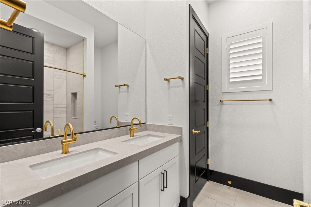 11041 Concord Valley Drive, Las Vegas, NV 89135 Sleek lines and modern finishes define this bathroom with a double vanity and stone counters.