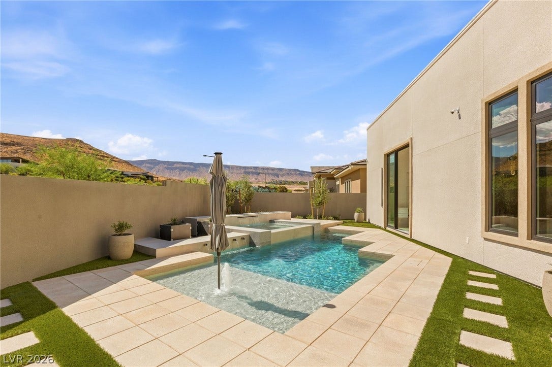 11041 Concord Valley Drive, Las Vegas, NV 89135 A sparkling geometric pool is framed by elegant stone pavers and dramatic mountain views.
