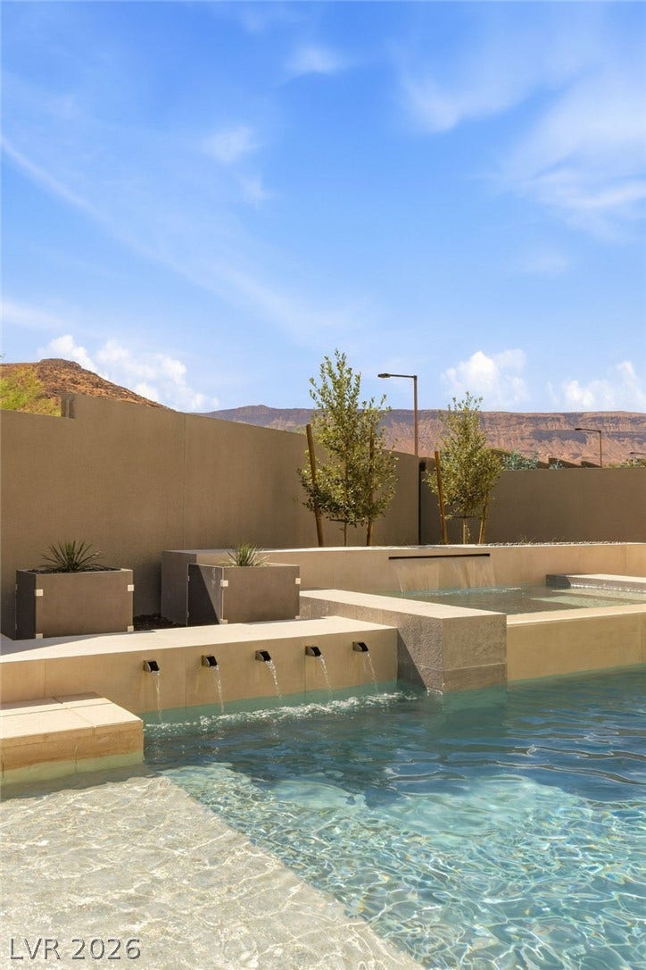11041 Concord Valley Drive, Las Vegas, NV 89135 Multi-tier water features cascade elegantly into a crystal clear pool set against mountain vistas.