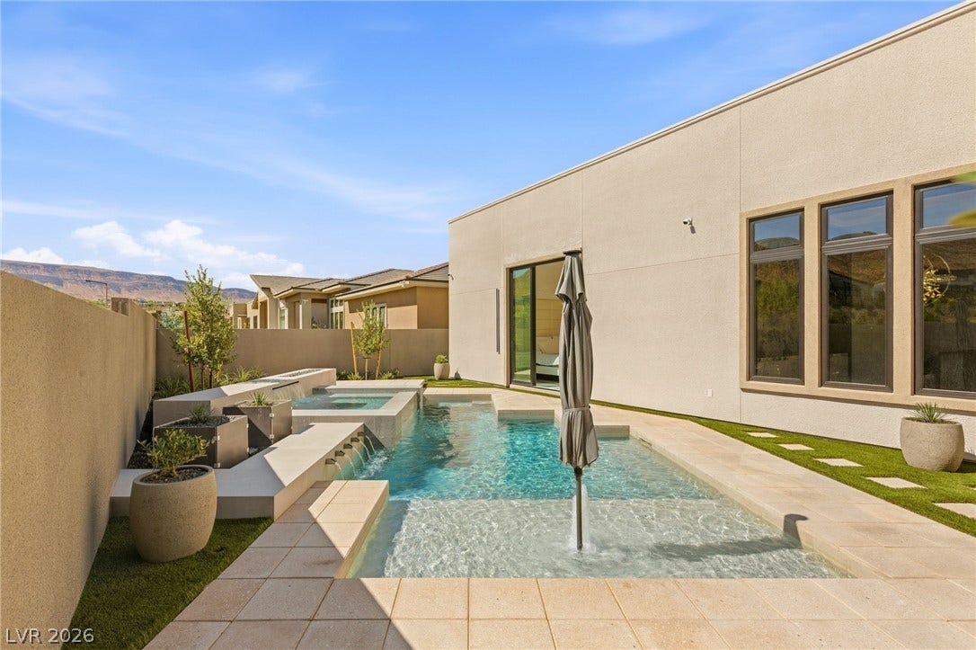 11041 Concord Valley Drive, Las Vegas, NV 89135 Geometric design highlights this modern backyard pool area with stone patio surrounds under clear blue skies.