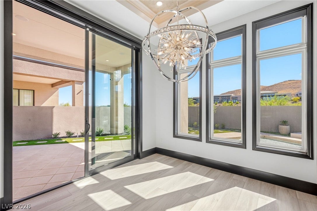 11041 Concord Valley Drive, Las Vegas, NV 89135 Sunlight streams through large windows and sliding glass doors, highlighting the light-toned wood flooring.