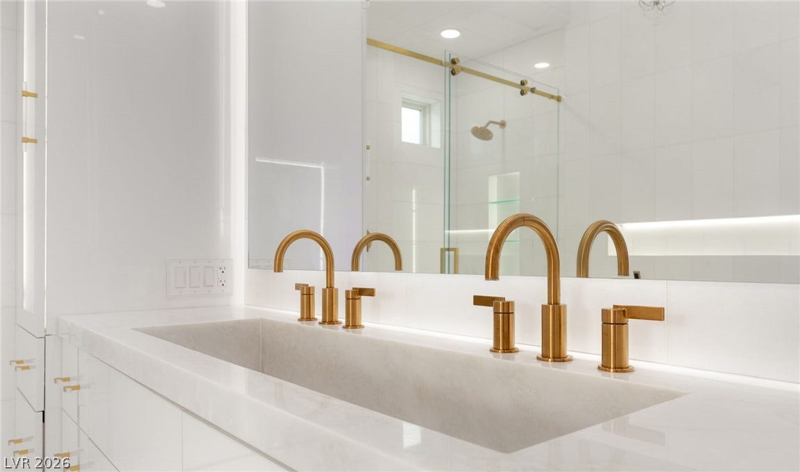 11041 Concord Valley Drive, Las Vegas, NV 89135 Gold fixtures accent a sleek double vanity topped with stone counters.