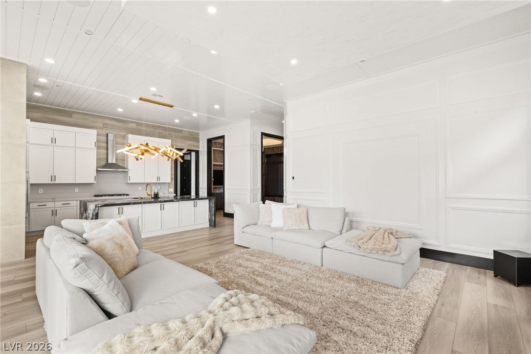 11041 Concord Valley Drive, Las Vegas, NV 89135 Gleaming hardwood floors and classic wall paneling elevate this open-concept main-level living space.