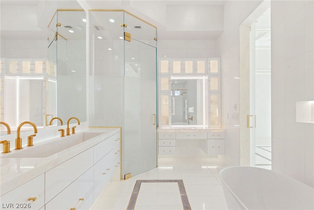 11041 Concord Valley Drive, Las Vegas, NV 89135 Gleaming surfaces and gold-toned fixtures elevate this elegant contemporary bathroom.