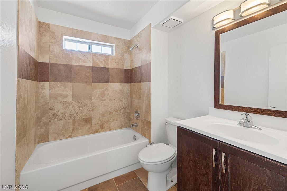 3450 Erva Street, #153, Las Vegas, NV 89117 Earth-toned tiles frame the tub and shower combination in this updated bathroom.