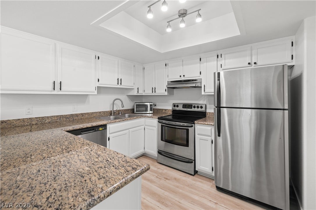 3450 Erva Street, #153, Las Vegas, NV 89117 Polished stone countertops pair beautifully with crisp white cabinetry in this functional kitchen.