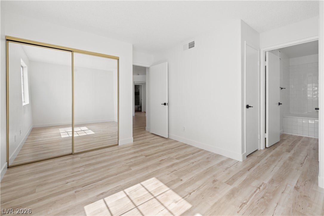 3450 Erva Street, #153, Las Vegas, NV 89117 Hardwood floors and sliding mirrored closet doors define this serene, light-filled bedroom suite.
