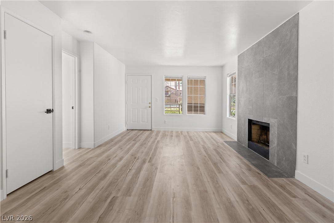 3450 Erva Street, #153, Las Vegas, NV 89117 A stone fireplace anchors the living space, framed by durable wood-look flooring and clean walls.