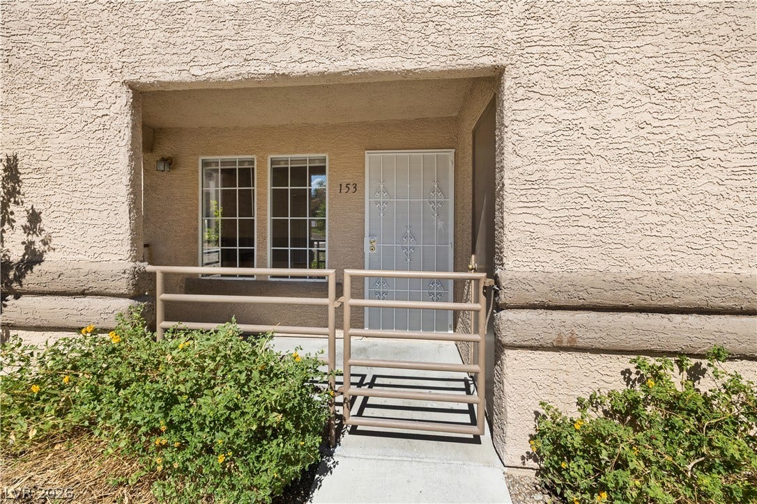 3450 Erva Street, #153, Las Vegas, NV 89117 A private gated entrance welcomes guests with classic stucco framing and dual multi-pane windows.