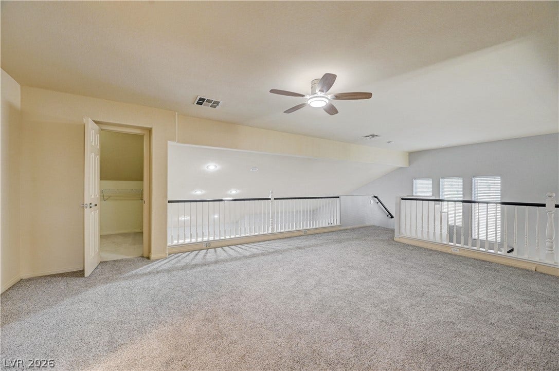 8908 Sheep Ranch Court, Las Vegas, NV 89143 An open upper-level loft features wall-to-wall carpeting and overlooking railings.