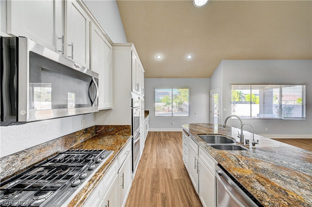 8908 Sheep Ranch Court, Las Vegas, NV 89143 Soaring vaulted ceilings and polished granite countertops define this open, airy kitchen layout.