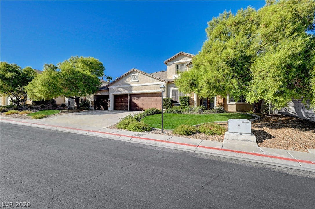 8908 Sheep Ranch Court, Las Vegas, NV 89143 Mature trees frame the multi-level facade of this residence featuring a spacious multi-car garage.