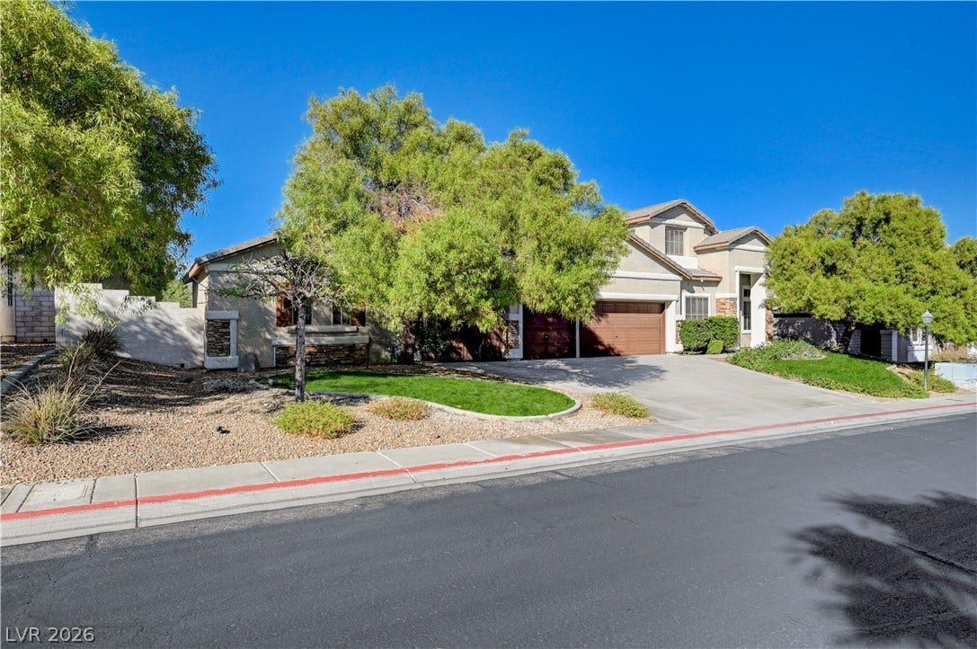 8908 Sheep Ranch Court, Las Vegas, NV 89143 Mature trees frame a welcoming facade complete with stone accents and a spacious driveway.