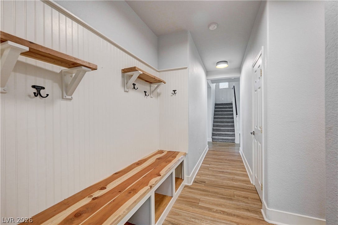 8908 Sheep Ranch Court, Las Vegas, NV 89143 Warm wood flooring and custom built-in bench seating welcome you into this functional entryway hallway.