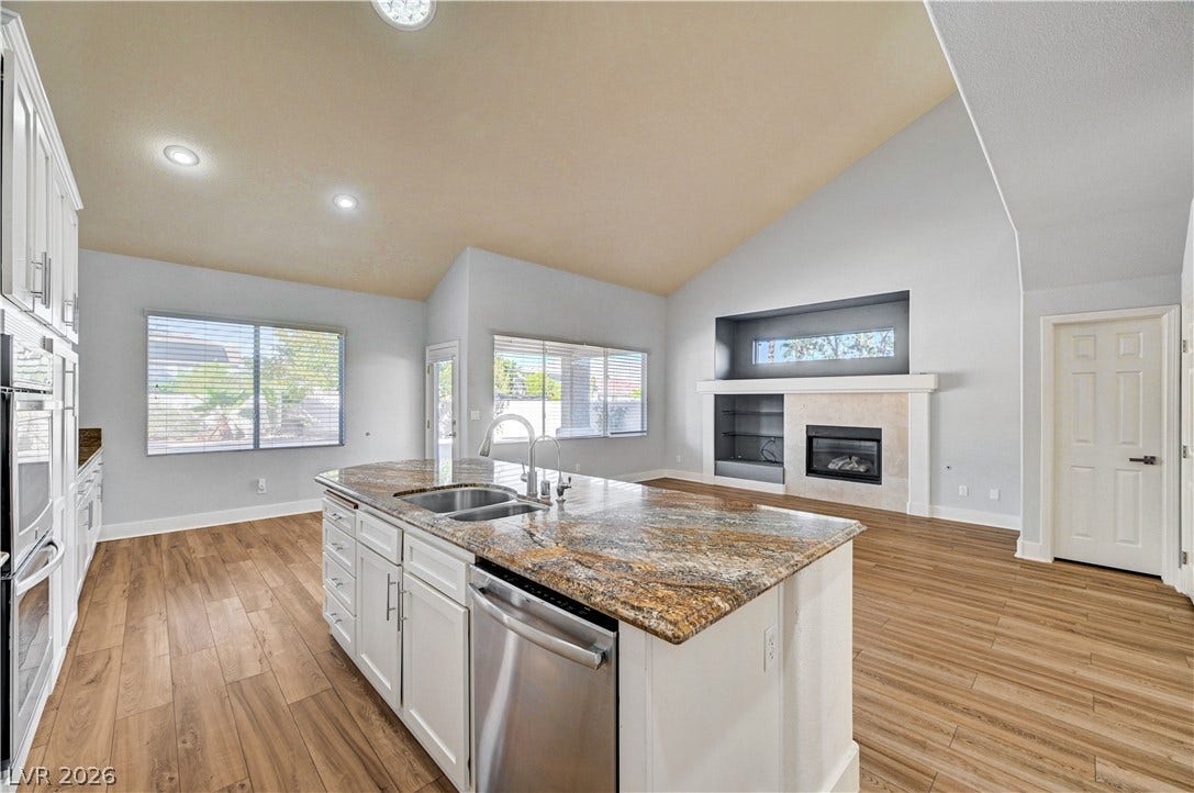 8908 Sheep Ranch Court, Las Vegas, NV 89143 An open floor plan connects the kitchen to a living area with vaulted ceilings.