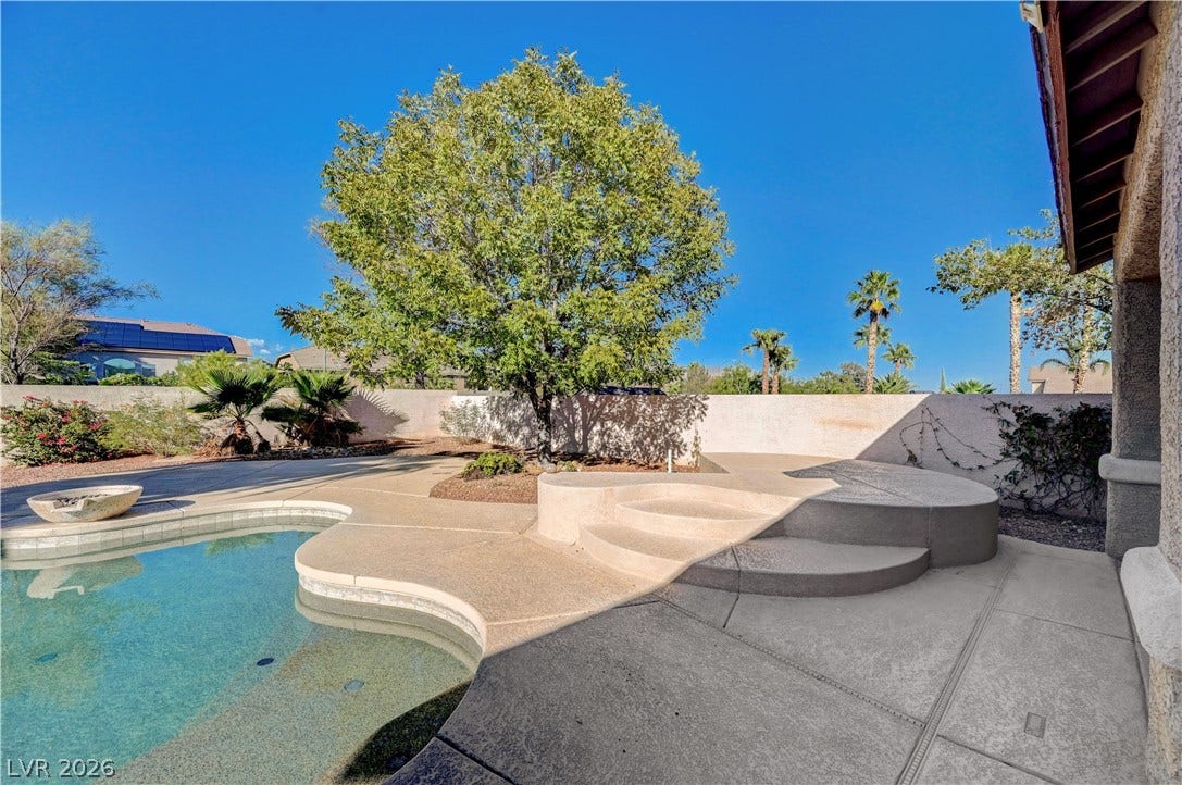 8908 Sheep Ranch Court, Las Vegas, NV 89143 A curved swimming pool integrates seamlessly with concrete decking and mature backyard landscaping.